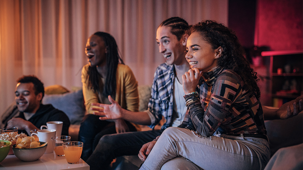 Tres mujeres viendo la televisión y tomando bebidas frías