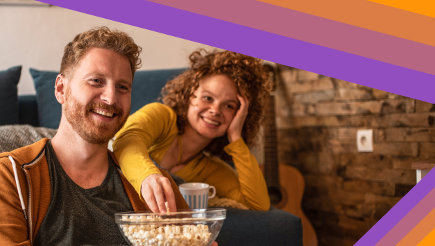 Una mujer con palomitas y disfrutando de un programa de TV con café